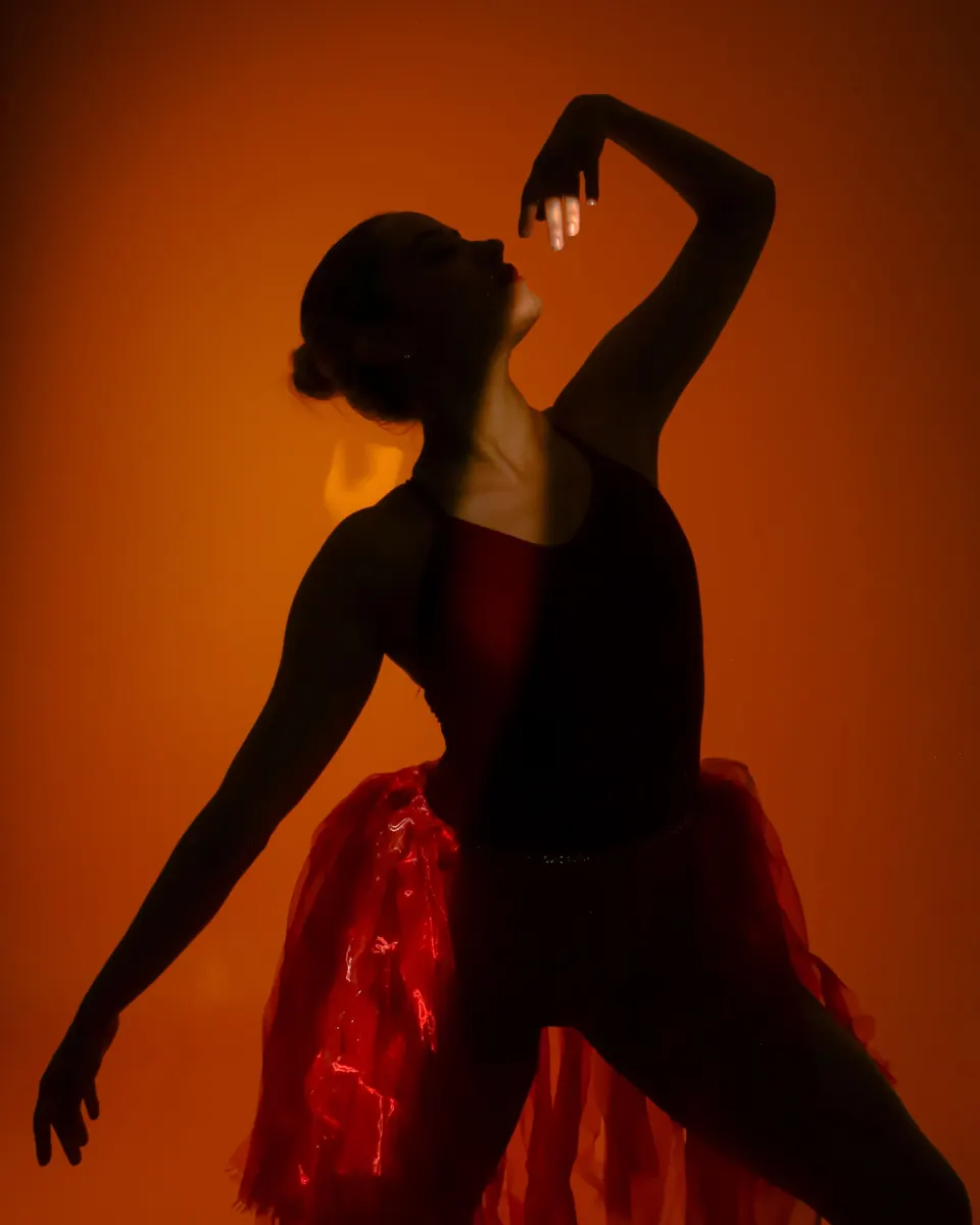 Dancer's silhouette against an orange wall