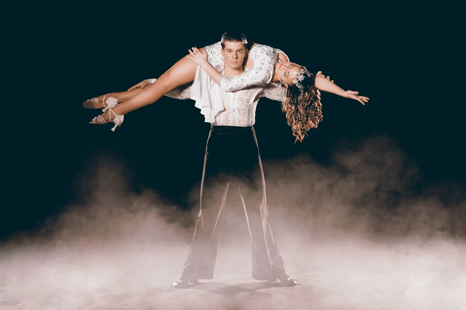 Two dancers in a lift, surrounded by stage smoke